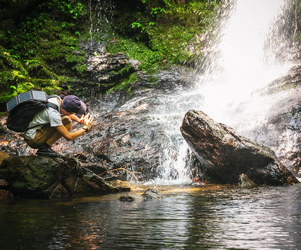 A photographer taking a photo of a waterfall