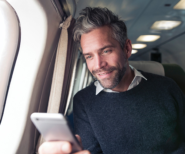 Man Holding Cell Phone in Cabin